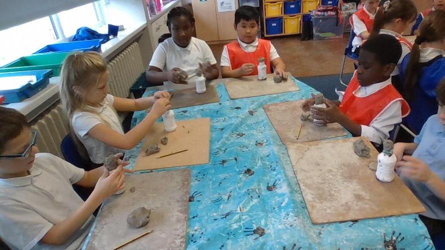 Then we used clay to fashion the heads onto the top of the jars